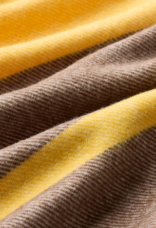 A close-up of a soft woven fabric with alternating diagonal stripes in warm brown and bright yellow.